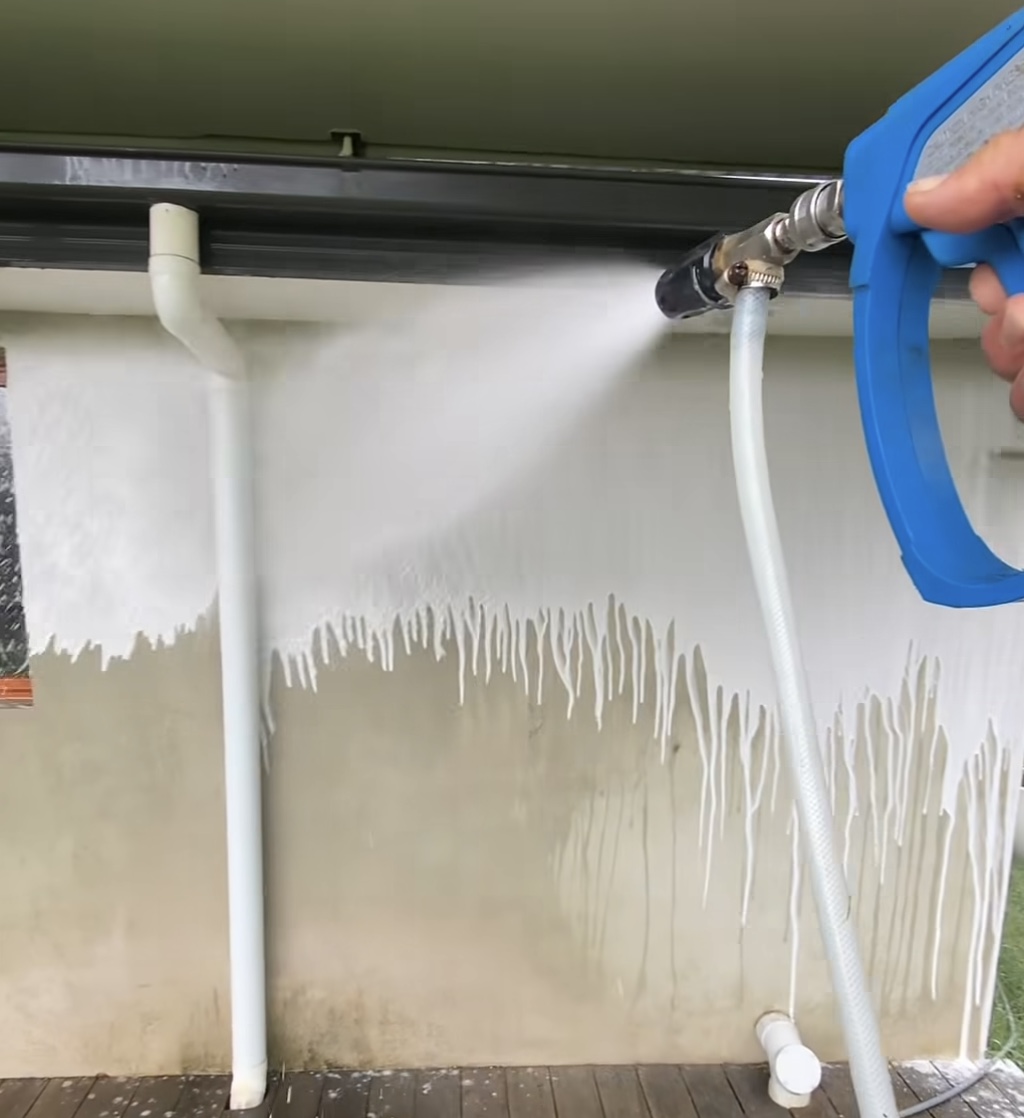 Soft-washing solution being applied from ground level